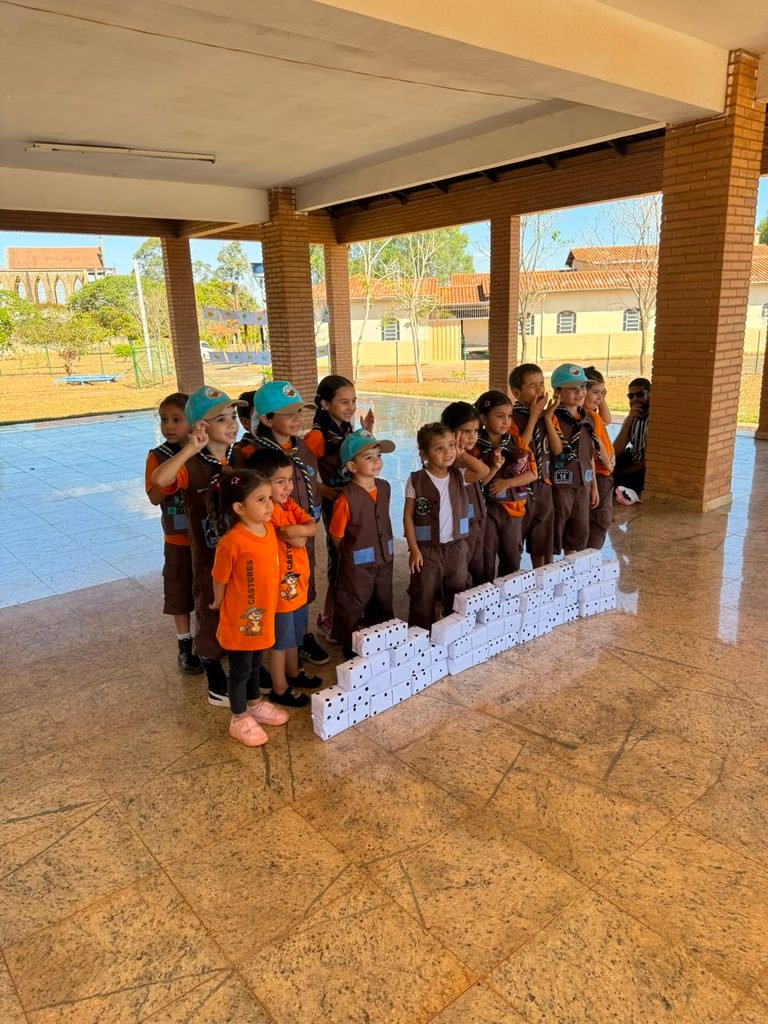 Castores do GESA reunidos ao lado da estrutura construída com peças de dominó gigante durante a atividade coletiva do DIQUE Descentralizado 2026, em Anápolis.